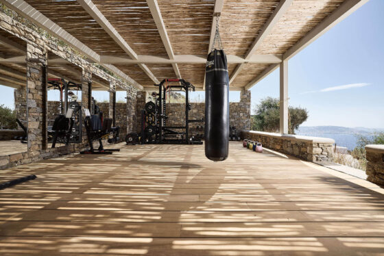 χώρος γυμναστηρίου σε εξωτερικό χώρο με ξύλινο δάπεδο από teak burma και πέργκολα από σύνθετη ξυλεία ελάτης. Σκίαση με κορμουδάκια ευκαλύπτου